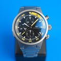 IWC Aquatimer Split Minute Frontansicht des schwarzen Zifferblatts mit gelben Akzenten und Titan-Lünette